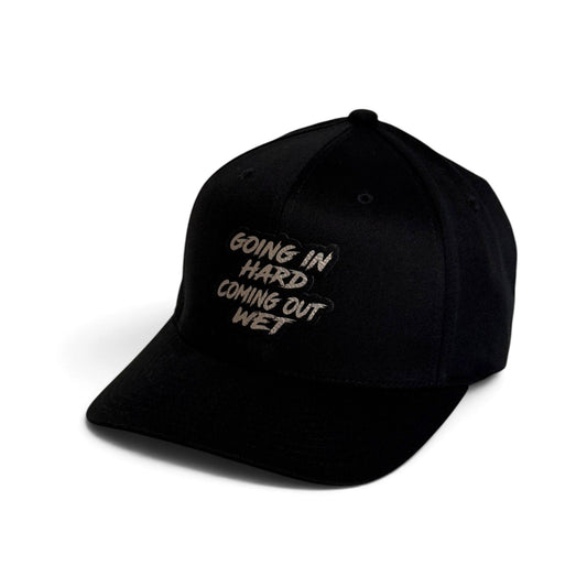 Crafted Merch black trucker hat featuring a patch with the text Going In Hard Coming Out Wet on the front panel