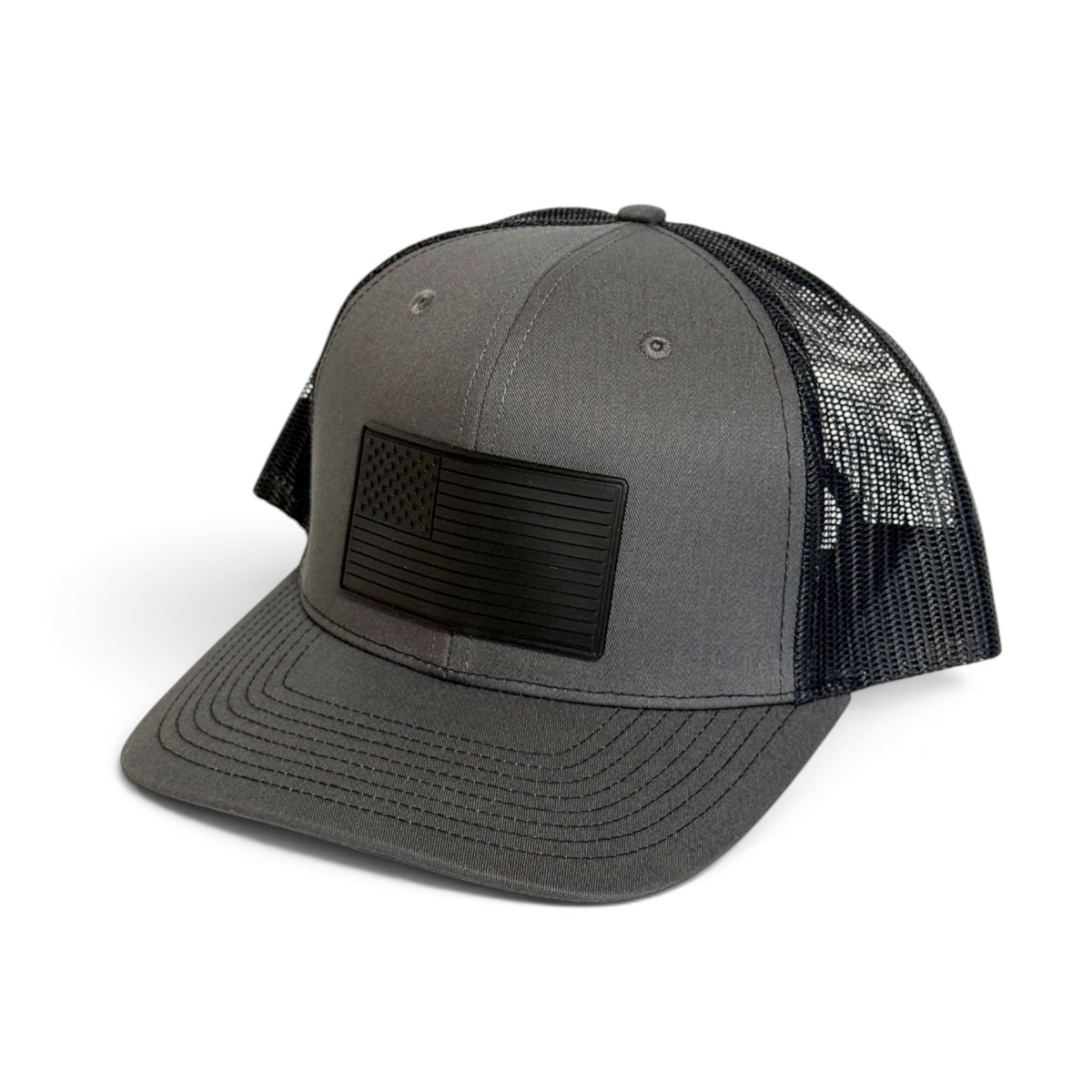 Crafted Merch grey trucker hat with a black monochromatic American flag PVC patch and breathable mesh back