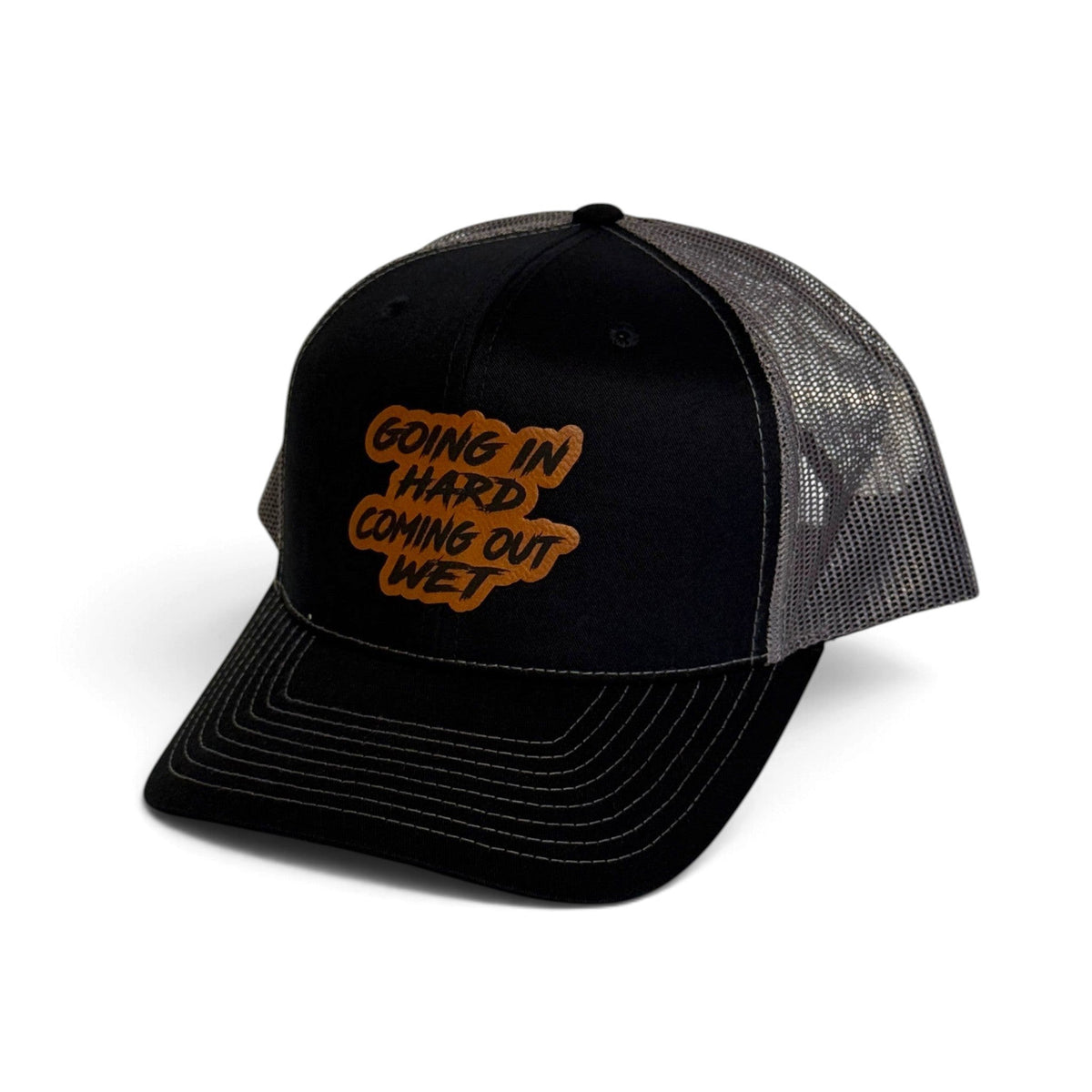 Crafted Merch black and grey trucker hat with a brown patch featuring the text Going In Hard Coming Out Wet