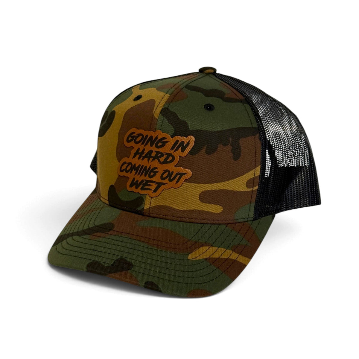 Crafted Merch trucker hat in camo print with a brown patch featuring the text Going In Hard Coming Out Wet