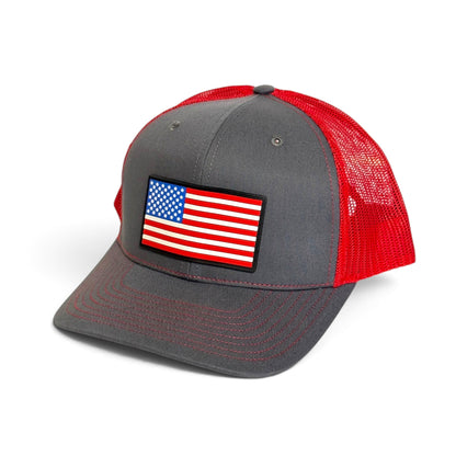 Crafted Merch grey and red trucker hat featuring a full-color American flag PVC patch and breathable mesh back