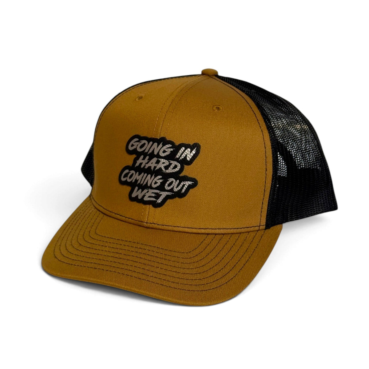 Crafted Merch trucker hat in tan with a black mesh back and a patch featuring the text Going In Hard Coming Out Wet
